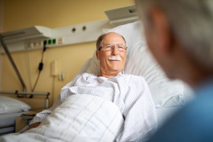 Patient im Krankenbett wird besucht