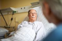 Patient im Krankenbett wird besucht